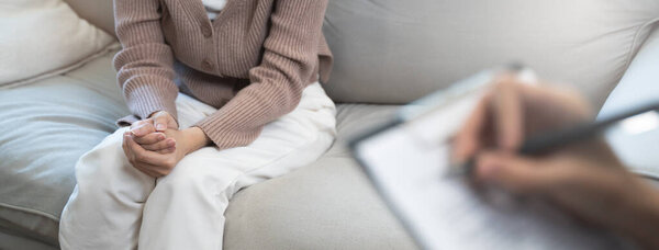 Молодая женщина на сеансе психотерапии разговаривает с психологом в офисе.