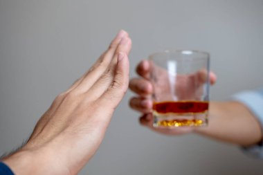 Drunk men deny drinking more glass of whisky by pushing away.