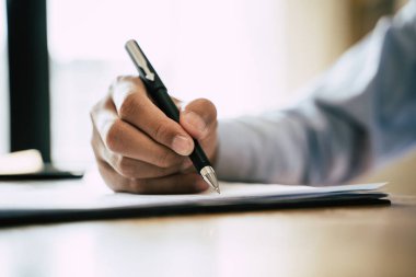 Close up hands of person signing on contract document