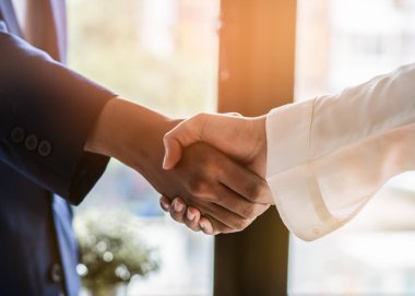 contractor and Client shaking hands with team builder in renovation site.