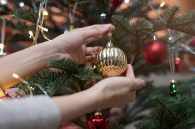 Close up hands of person decorating Christmas tree