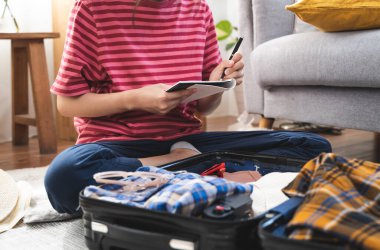 people check clothes into luggage in suitcase checklist before holidays trip