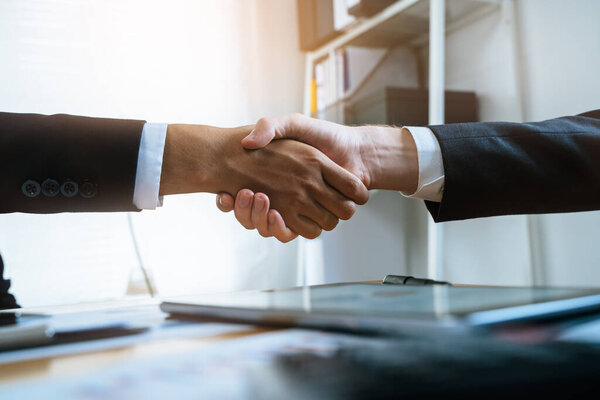 client and banker shaking hands  on the meeting table after business investment budget done