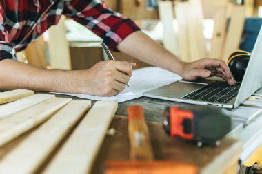 Hands of person doing diy project at home. Man measuring wood to doing cabinet craftworks as a hobby.