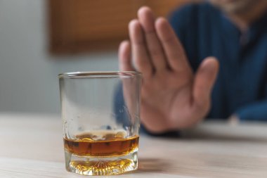 Drunk men deny drinking more glass of whisky by pushing away.