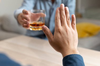 person deny alcohol drink from his friend