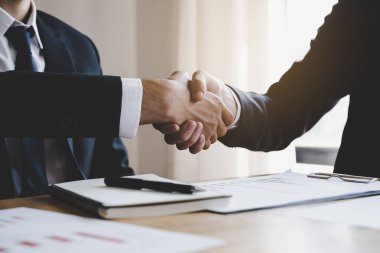 hand of client and banker shaking hands  on the meeting table after business investment budget done