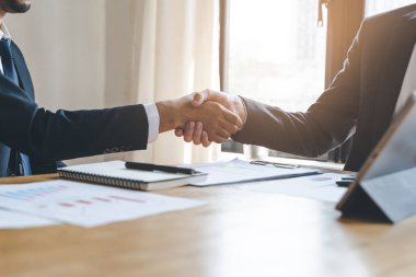 hand of client and banker shaking hands  on the meeting table after business investment budget done