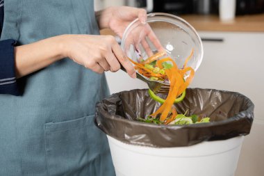 global food pollution concept. Woman throwing a leftover breakfast to the trash.