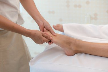 Relax with aroma oil massage in spa salon. woman lying on the bed relaxing with foot massage during treatment in beauty spa.