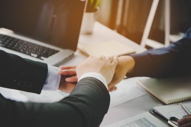 Group of employees stacking hands together showing trust in teammates in the meeting to start new project.