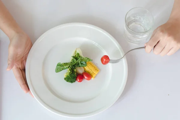 Eat less and eat healthy. person eating vegetable in dinner during control calories on dieting.