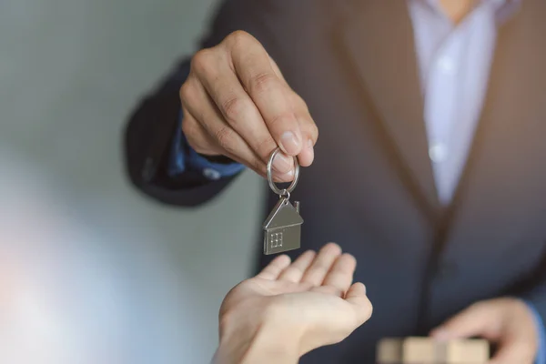 stock image close up view hand of property realtor / landlord giving key house to buyer / tenant.