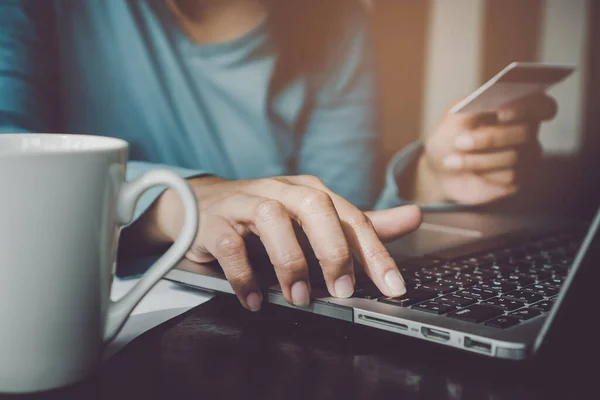 Modern business technology. Close up hands of woman using computer and credit card paying bills for online ordering.