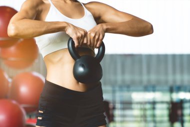 Women lifting weight dumbbells in gym.