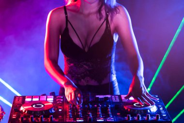 Sexy Dj mixing music in the party.