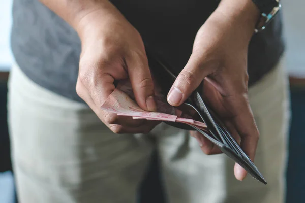 Man holding wallet with full of money prepare for spend.