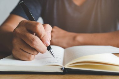 Not defterine not yazan öğrencinin elini kapat.