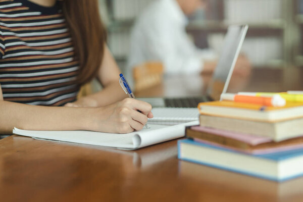 female asian student studying and reading book in library