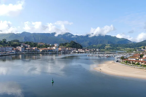 Ribadesella, Asturias. İspanya 'nın kuzeyindeki sahil kasabasında Picos de Europa dağlarının silueti ve Sella nehrinin ağzıyla Atlantik Okyanusu' nun birleştiği yerde..