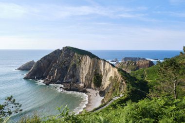 Asturias 'taki muhteşem sessizlik plajı kaya oluşumları ve bitki örtüsüyle çevrili kayalıklarla çevrili..