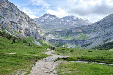 Ordesa Vadisi 'ndeki yürüyüşçüler Ordesa ve Monte Perdido Ulusal Parkı' ndaki büyük dağların ortasında dar bir taş patika boyunca yürüyorlar. Aragon, İspanya