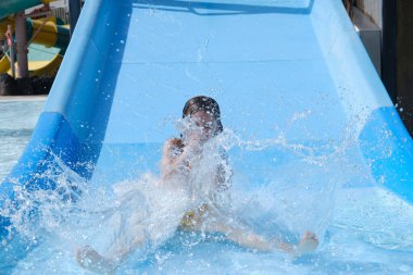 Su parkında su kaydırağındaki kız.