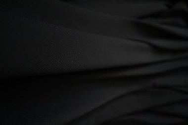 Siyah kumaş dokusu arka plan, dalgalı kumaş kaygan siyah renk, lüks saten kumaş dokusu.