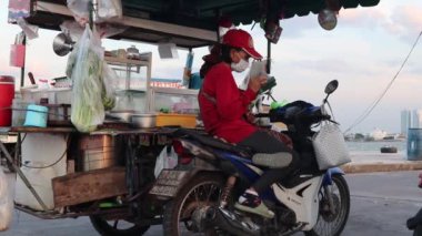 Mobil Tayland yemekleri satan Taylandlı bir kadın motosikletle bağlanmış.