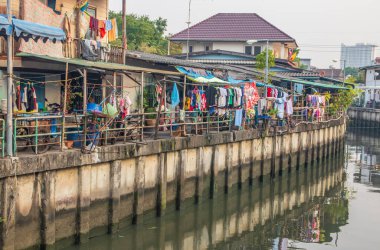 Tayland ve Asya 'da balıkçı tekneleri, binaları ve ev cepheleri olan klong veya nehir kanalı