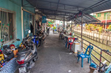 Tayland ve Asya 'da balıkçı tekneleri, binaları ve ev cepheleri olan klong veya nehir kanalı