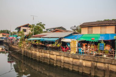 Tayland ve Asya 'da balıkçı tekneleri, binaları ve ev cepheleri olan klong veya nehir kanalı