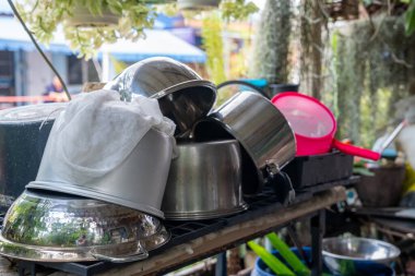 Metalden yapılmış tencere ve kaseler ve yağlı plastik mutfak gereçleri.