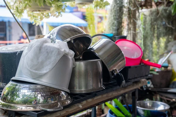 Metalden yapılmış tencere ve kaseler ve yağlı plastik mutfak gereçleri.