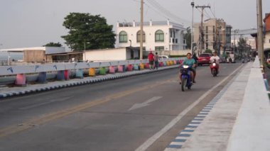 Tayland 'da Pattaya Bölgesi Chonburi' nin kuzey Naklua Mahallesi 'nde yavaş çekimde çekilen köprüde arabalı, scooterlı ve yaya trafiği