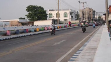 Tayland 'da Pattaya Bölgesi Chonburi' nin kuzey Naklua Mahallesi 'nde yavaş çekimde çekilen köprüde arabalı, scooterlı ve yaya trafiği