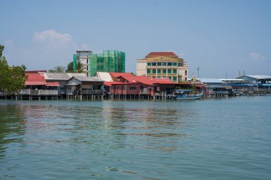 Malezya 'da Penang' ı çiğnemek vahşi binalarda ahşap evleri ve sudaki iskeleleri olan bir yer..