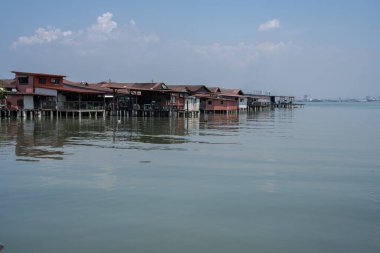 Malezya 'da Penang' ı çiğnemek vahşi binalarda ahşap evleri ve sudaki iskeleleri olan bir yer..