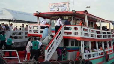 Turistlere, kendilerini iskeleden komşu bir adaya götürecek bir feribota binmeleri için personel tarafından yardım ediliyor. Pattaya Chonburi bölgesi Tayland Asya 15. Aralık 2024 