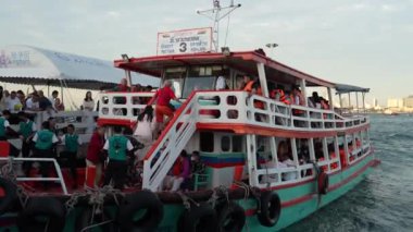 Turistlere, kendilerini iskeleden komşu bir adaya götürecek bir feribota binmeleri için personel tarafından yardım ediliyor. Pattaya Chonburi bölgesi Tayland Asya 15. Aralık 2024 