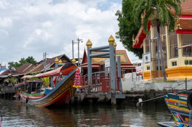 Chao Phraya nehrinin uzun kuyruklu ahşap botları ve Bangkok Tayland Asya 'daki konut binaları olan klong veya nehir kanalı.
