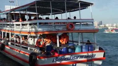 Tayland körfezi dalgalar yaratırken, turistler veya yolcular feribotla bir rıhtımdan bir adaya taşınıyor. Pattaya Chonburi bölgesi Tayland ve Asya