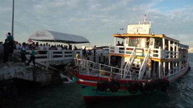 Tayland körfezi dalgalar yaratırken, turistler veya yolcular feribotla bir rıhtımdan bir adaya taşınıyor. Pattaya Chonburi bölgesi Tayland ve Asya