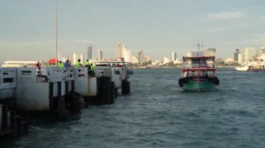 Tayland körfezi dalgalar yaratırken, turistler veya yolcular feribotla bir rıhtımdan bir adaya taşınıyor. Pattaya Chonburi bölgesi Tayland ve Asya