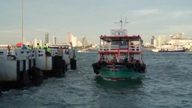 Tayland körfezi dalgalar yaratırken, turistler veya yolcular feribotla bir rıhtımdan bir adaya taşınıyor. Pattaya Chonburi bölgesi Tayland ve Asya