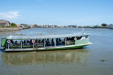 Yolcular, feribotla nehrin bir tarafından diğerine Tayland Asya 'daki Bangkok yakınlarındaki Mahachai Market' e naklediliyor.