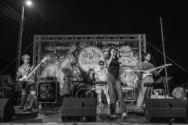 Tayland 'ın Tayland bölgesindeki Naklua semti Chonburi' de düzenlenen bir sokak festivali sırasında sahnedeki bir Tayland rock müzik grubu tek renkli veya siyah beyaz, Sony ILCE-7M4 ve Sony Lens FE 24-70mm F / 2.8 GM II ile fotoğraflanmıştır.