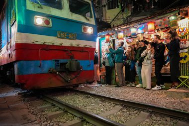 Bir lokomotif, Vietnam 'daki Hanoi Asya' dan, birçok ziyaretçi barının doğrudan demiryolu hattında bulunduğu Eski Mahalle 'nin tren sokağına giriyor.