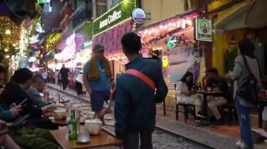 İnsanlar, gezginler ve turistler Vietnam 'da Hanoi' nin Eski Mahallesi 'ndeki tren raylarında yürüyor ya da duraklıyor.  
