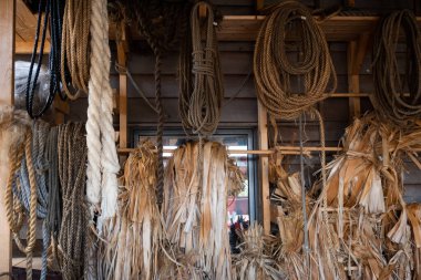 Spools of twine, bast hanging on the wall, thick handmade ropes for boats.